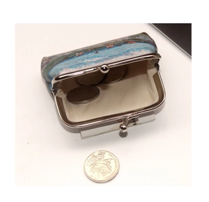 Detail of vintage impressionist canvas coin purse with metal clasp and inner coins