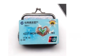 Mini kiss-lock coin purse in iridescent faux leather shown next to a bank card for size