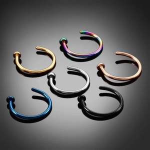 Detailed view of six colorful stainless steel C-shaped nose rings on reflective background
