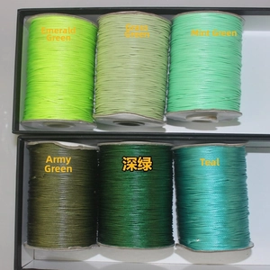Detail view of six green shades of waxed cord rolls including emerald and mint green