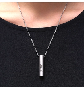 Close-up of MOM engraved silver cremation urn necklace on a female model with black shirt