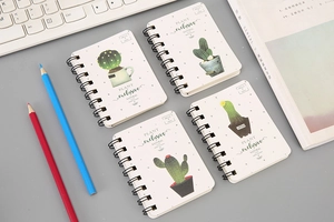 Flat lay of four A7 spiral notebooks featuring diverse cactus illustrations and typography