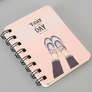 Close-up of pink A7 spiral notebook featuring an artistic illustration and quote