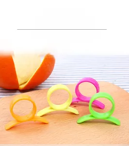 Macro detail of snail-shaped plastic orange peelers on a wooden board for citrus fruit