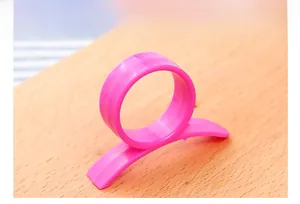 Macro view of smooth pink plastic fruit peeler tool on light wood background