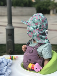 Detail of baby sun hat with neck protection flap and mint green cartoon print fabric