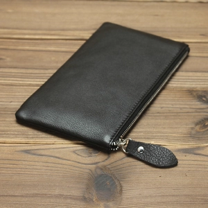Detailed close-up of a minimalist black crazy horse leather wallet with silver zipper