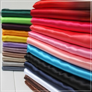 Stack of colorful narrow satin scarves showing various vibrant shades and smooth texture