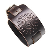 Macro detail of dark brown leather wide bracelet with embossed spiral sun and buckle strap