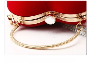 Nahaufnahme der roten Herz-Clutch mit Goldbeschlag und Kristallverschluss-Detail