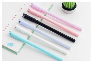 Set of six colorful cartoon cat gel pens arranged on desk with strawberry notebook