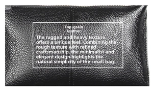 Detail shot of black top grain cowhide leather showing natural lychee texture and stitching