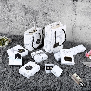 Detail of marble pattern gift box with elegant black ribbon and matching paper handbag