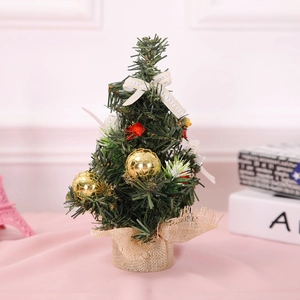 Mini green Christmas tree with gold baubles and a rustic burlap base for tabletop decor