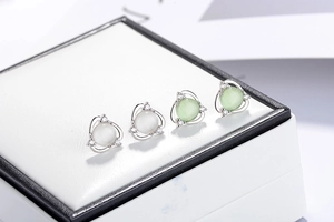 Detailed macro view of white and green opal flower earrings with zircon insets