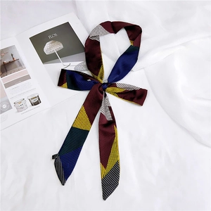 Detailed close-up of long narrow silk twilly scarf with geometric patchwork pattern