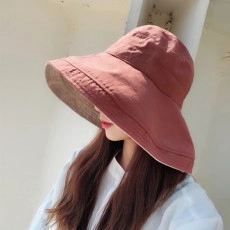 Side view of brick red long brim sun hat showing fabric texture on a model