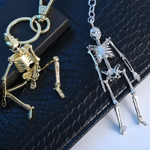 Detailed close-up of metal skull keychains in gold and silver finishes on black leather
