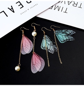 Detail of handmade butterfly wing earrings featuring sheer tulle, pearls, and gold hooks