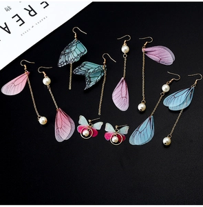 Detail of handmade butterfly wing earrings with sheer fabric, pearls and gold tassels