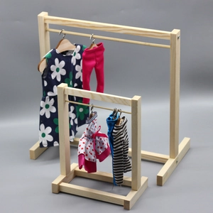 Miniature wooden doll hangers in two sizes with various colorful doll clothes on gray background