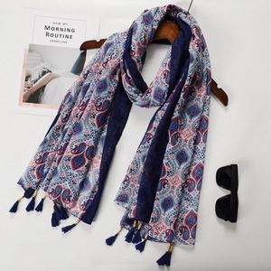 Detail of bohemian paisley scarf with handmade blue tassel charms and fringe edge