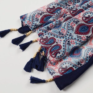 Detail of bohemian cotton linen scarf featuring paisley patterns and wooden bead tassels