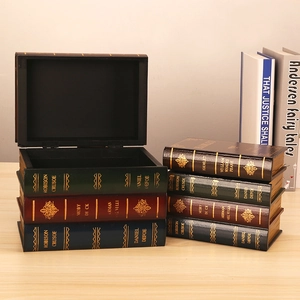 Set of vintage faux book storage boxes in various colors on a wooden desktop