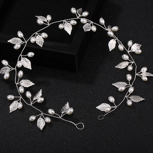 Detailed view of handmade silver bridal vine with white pearls and metal leaf accents
