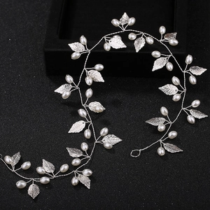 Detailed view of handmade silver bridal hair vine with pearls and metal leaf elements