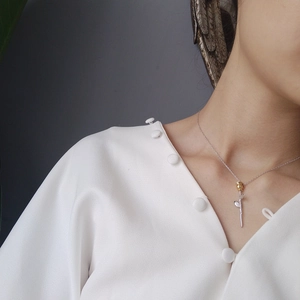 Detailed view of two-tone rose flower pendant necklace worn on neck for women