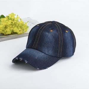 Detail view of dark blue denim baseball cap featuring vintage distressed brim and orange stitching