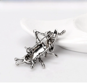 Close-up of vintage silver grasshopper brooch showing the secure back pin clasp detail