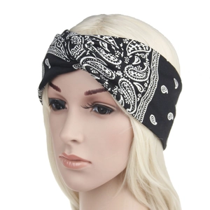 Detail showing a black paisley print knotted headband on a model for bohemian styling