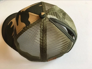 Vista dettagliata del cappellino mimetico con rete traspirante e foro per coda di cavallo