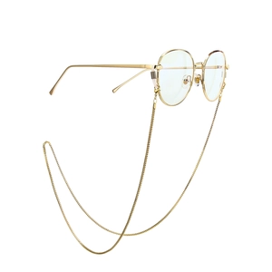 Detail of round gold metal sunglasses with matching fine link chain on white background