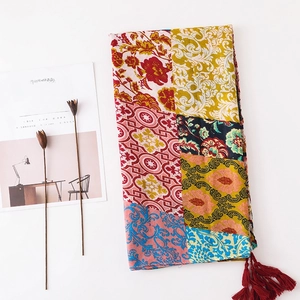 Detailed view of bohemian floral cotton shawl with rich colors and crimson tassels