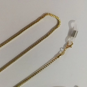 Detailed macro view of golden box chain with lobster clasp and silicone glasses loops