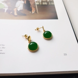 Close-up of vintage S925 silver stud earrings with green agate and 18K gold finish