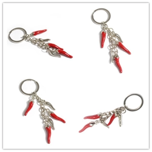 Close-up of four red chili pepper alloy keychains on a clean white background