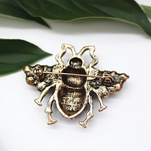 Detailed back view of vintage bronze bee brooch featuring secure pin clasp and textures
