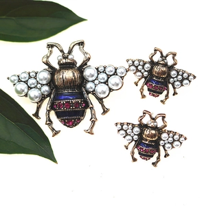 Detail of vintage bee brooches with pearls and blue enamel in three sizes for women