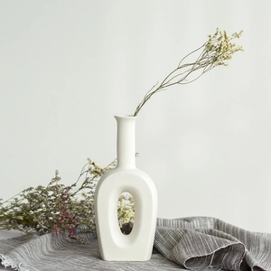 Minimalist white ceramic vase with hollow ring design and dried flowers for home decor