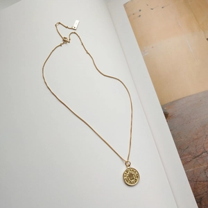 Close-up of 925 silver coin pendant necklace with crown crest and hallmark tag