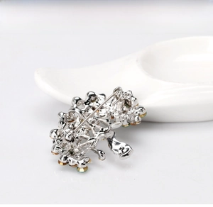 Detail view of the silver-tone alloy brooch back showing the classic pin clasp mechanism