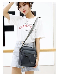 Detail view of water-resistant Oxford crossbody bag with multiple zipper compartments