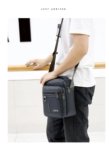 Detail of waterproof Oxford fabric crossbody bag showing multiple zipper compartments and texture
