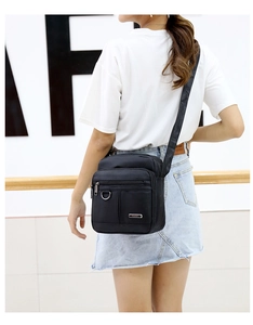 Rear view of man wearing waterproof black oxford fabric crossbody bag with adjustable strap