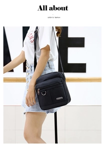 Close-up of black waterproof nylon crossbody bag featuring metallic logo and D-ring