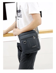 Detail of dark grey waterproof oxford shoulder bag with multiple zippered pockets